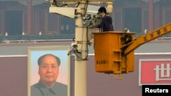 A man works on a security camera that was installed at Tiananmen Square in Beijing, November 1, 2013. China's domestic security chief believes a fatal vehicle crash in Beijing's Tiananmen Square in which five died was planned by a Uighur separatist group,