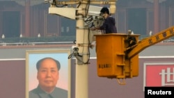 FILE - A man works on a security camera that was installed at Tiananmen Square in Beijing, November 1, 2013. (REUTERS/Kim Kyung-Hoon)