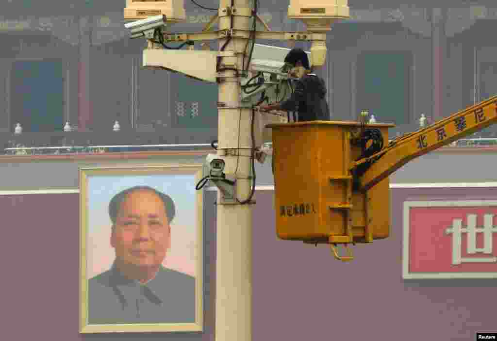 A man installs a security camera  at Tiananmen Square in Beijing, Nov. 1, 2013, very close to the site of a fatal vehicle crash in which five people died.
