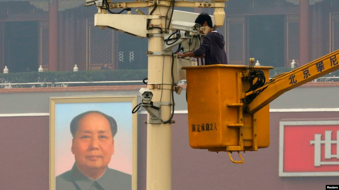 FILE - A man works on a security camera that was installed at Tiananmen Square in Beijing, November 1, 2013. (REUTERS/Kim Kyung-Hoon)