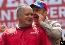 FILE - National Assembly lawmaker Diosdado Cabello listens to Venezuela's Vice President Tareck El Aissami at a rally opposing the United States and possible OAS sanctions, in Caracas, Venezuela, March 28, 2017.