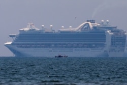 A fishing boat sails past the Princess Cruises' Ruby Princess cruise ship as it docks in Manila Bay during the spread of the coronavirus disease (COVID-19), in Cavite city, Philippines, May 7, 2020.