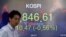 A currency trader walks by a screen showing the Korea Composite Stock Price Index at the foreign exchange dealing room in Seoul, South Korea, April 16, 2020. 