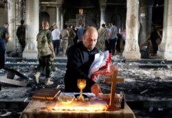 Seorang Kristen Irak bersiap untuk misa Minggu pertama di Grand Immaculate Church sejak direbut kembali dari ISIS di Qaraqosh, dekat Mosul di Irak, 30 Oktober 2016. (Foto: Reuters)