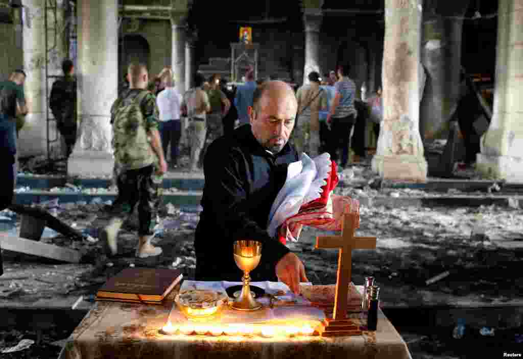 An Iraqi Christian prepares for the first Sunday Mass at the Grand Immaculate Church since it was recaptured from Islamic State in Qaraqosh, near Mosul, Oct. 30, 2016.