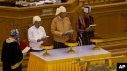 Htin Kyaw, second right, takes oaths as Myanmar's new president during a sworn-in ceremony in Myanmar's parliament in Naypyitaw, Myanmar, Wednesday, March 30, 2016.