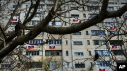 FILE - Russian flags are seen hung from an apartment building in a residential district in Sevastopol, Crimea, March 14, 2014.