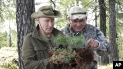 In this photo taken on Sunday, Aug. 26, 2018, Russian President Vladimir Putin, left, and Defense Minister Sergei Shoigu rest during a break in the Siberian Tuva region, Russia. (Alexei Nikolsky/Sputnik, Kremlin Pool Photo via AP)