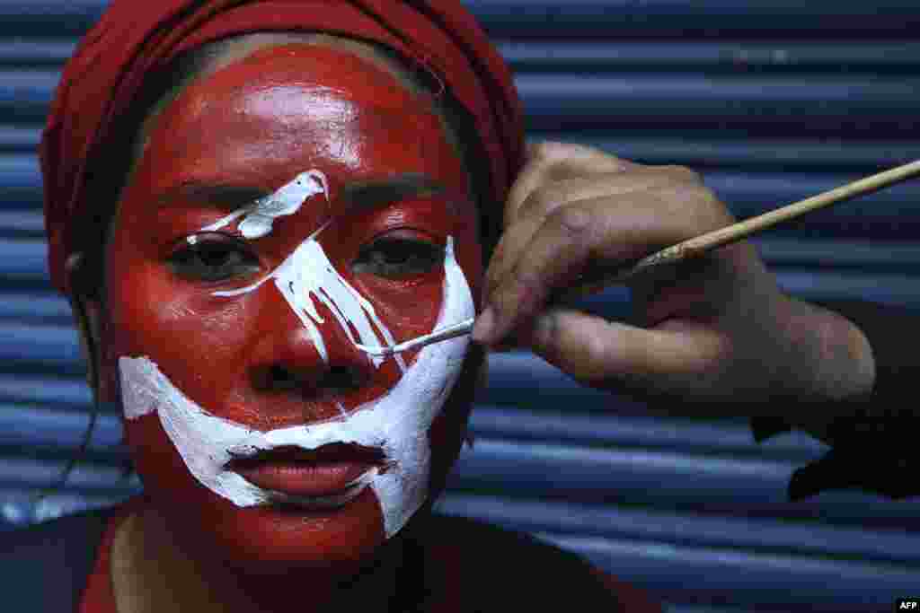 A supporter of a faction of the ruling Nepal Communist Party (NCP) gets her face painted before taking part in a &quot;victory&quot; rally after Supreme Court ruling to overturn the prime minister&#39;s decision to dissolve parliament, in Kathmandu.