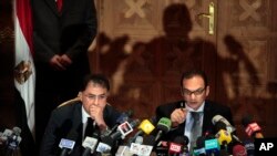 FILE - Egyptian investigative judges Sameh Abu Zeid, right, and Ashraf el-Ashmawi, who are investigating the case of foreign funding of NGOs, talk during a press conference at the Ministry of Justice in Cairo, Egypt, Feb. 8, 2012. 
