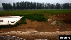 지난 2014년 6월 중국 베이징 외곽에 불법 건립된 골프장을 폐쇄한 후 옥수수밭으로 바꾸고 있다. 사람들이 접근하지 못하도록 담벼락에 깨진 유리조각을 꽂아놓았다.