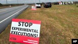 Activistas contra la pena de muerte colocaron carteles a lo largo de la carretera que conduce al Centro Correccional Holman en Atmore, Alabama, antes de la ejecución programada de Kenneth Eugene Smith el jueves 25 de enero de 2024.