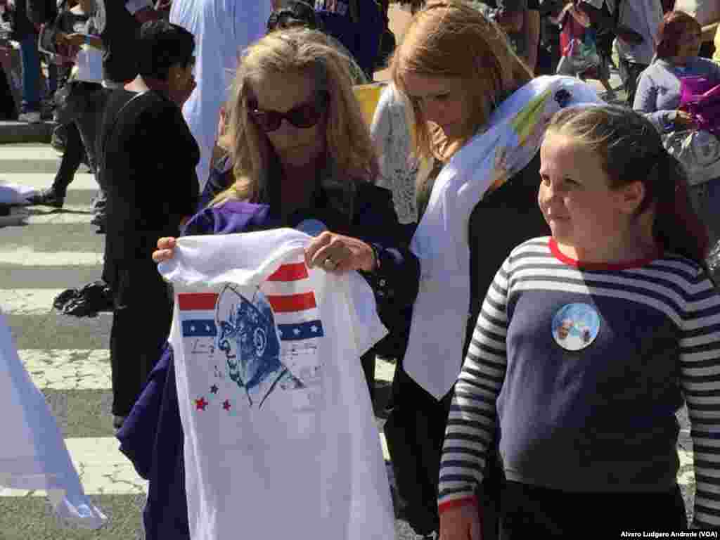 Pessoas compram t-shirts com a imagem do Papa em Washington DC. 