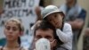 A father with his son attend a global protest on climate change in Rio de Janeiro, Brazil, Friday, Sept. 20, 2019. Across the globe, hundreds of thousands of people took to the streets Friday to demand that leaders tackle climate change in the run-up to a U.N. summit. (AP Photo/Silvia Izquierdo)