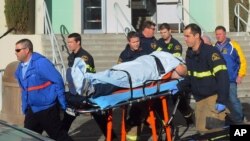 Radnici hitne pomoći sprovode ranjenog učenika srednje škole u Taftu posle jučerašnje pucnjave