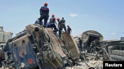 Rescuers work at the site of a collision between a passenger train and a truck in the southern city of Fahs, Tunisia, June 16, 2015.