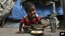 An Indian child eats midday meal organized by Andhra Pradesh government at a shanty area in Hyderabad, India, Jan. 11, 2012. 