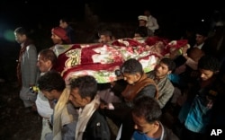 FILE - Mourners carry the body of Youssef al-Salmi, 10, who was killed when a bomb exploded while he was playing with it near his family's house in Hasn Faj Attan village, in the mountainous outskirts of Sanaa, Yemen.