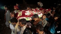 FILE - Mourners carry the body of Youssef al-Salmi, 10, who was killed when a bomb exploded while he was playing with it near his family's house in Hasn Faj Attan village, in the mountainous outskirts of Sanaa, Yemen.