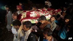 FILE - Mourners carry the body of Youssef al-Salmi, 10, who was killed in July while playing with a bomb near a village neighboring Sanaa, Yemen. Airstrikes reportedly have killed 11 civilians in Saada.