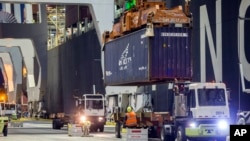 FILE - Ship to shore cranes and gangs of longshoremen work the container ship YM Witness at the Georgia Ports Authority's Port of Savannah, Sept. 29, 2021, in Savannah, Georgia.