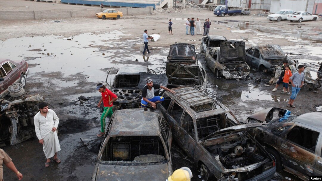 Warga berkumpul di lokasi serangan bom mobil di Baghdad, Senin (27/5). 