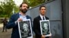 The director of the Reporters Without Borders (RSF) regional office for Latin America Artur Romeu (L) holds a drawing of Guatemalan journalist Jose Ruben Zamora, accompanied by Zamora's son Jose, as they leave the Mariscal Zabala Men's Prison in Guatemala