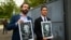The director of the Reporters Without Borders (RSF) regional office for Latin America Artur Romeu (L) holds a drawing of Guatemalan journalist Jose Ruben Zamora, accompanied by Zamora's son Jose, as they leave the Mariscal Zabala Men's Prison in Guatemala
