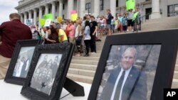 FILE - Family photographs of Joshua Holt, an American jailed in Venezuela, are part of a rally at the Utah State Capitol, July 30, 2016, in Salt Lake City. Holt was arrested on suspicion of weapons charges after he traveled to Venezuela on a tourist visa to marry a fellow Mormon he met on the internet.