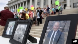 FILE - Family photographs of Joshua Holt, an American jailed in Venezuela, are part of a rally at the Utah State Capitol in Salt Lake City, July 30, 2016.