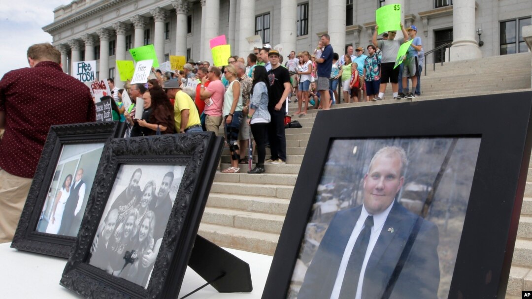 FILE - Family photographs of Joshua Holt, an American jailed in Venezuela, are part of a rally at the Utah State Capitol in Salt Lake City, July 30, 2016.