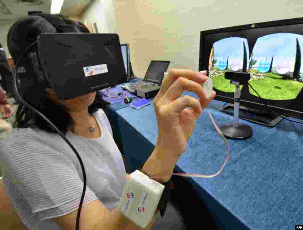 일본 도쿄 인근 츠쿠바에서 열린 3D 가상현실 장비 체험 행사에서 한 기자가 직접 장비를 시연하고 있다.