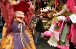 Seorang pria berdiri di dekat sebuah kios di Pasar Natal tradisional di pusat kota Roma. (Foto: REUTERS/Tony Gentile)