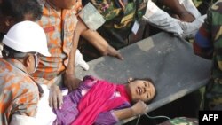 Spasioci evakuišu jednu od preživelih žrtava srušene fabrike odeće u predgrađu Dake, u Bangladešu