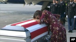 In this frame from video, Myeshia Johnson cries over the casket in Miami, Florida, Oct. 17, 2017, of her husband, Sgt. La David Johnson, who was killed in an ambush in Niger.
