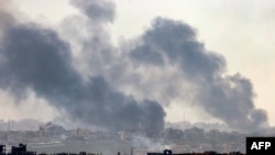 Uma fotografia tirada da cidade meridional de Sterod mostra o fumo a subir por cima de edifícios destruídos no norte da Faixa de Gaza durante um bombardeamento do exército israelita em 5 de janeiro de 2025, no meio da guerra em curso entre Israel e os militantes do Hamas.