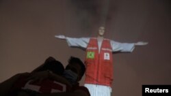 La escultura del Cristo Redentor, en el morro de Corcovado, en Río de Janeiro, Brasil, iluminado en honor a los miembros de la Cruz Roja que combaten la pandemia en el país, el 31 de agosto de 2020.