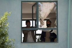 Afghans clear glass from a broken window of a house after a suicide bomb attack on the southern outskirts of Kabul, Afghanistan, April 29, 2020.