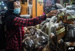 Sebuah toko jamu di pasar tradisional di Yogyakarta menjual berbagai ramuan tradisional untuk meningkatkan kekebalan tubuh di tengah pandemi virus corona (Covid-19), 3 Maret 2020. (Foto: AFP)