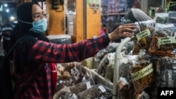 Sebuah toko jamu di pasar tradisional di Yogyakarta menjual berbagai ramuan tradisional untuk meningkatkan kekebalan tubuh di tengah pandemi virus corona (Covid-19), 3 Maret 2020. (Foto: AFP)
