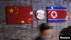 中国浙江宁波已经关张的朝鲜餐厅外悬挂的朝鲜与中国国旗。（2016年4月12日）