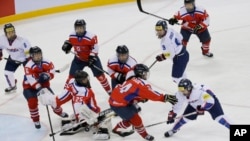 Lee Eun-ji (Korsel, bawah kanan) mencetak gol saat Kim Kum Bok (Kout, bawah nomor dua dari kanan), mencoba menghalangi masuknya bola ke gawang mereka dalam pertandingan IIHF Ice Hockey Women's World Championship Division II, di Gangneung, Korea Selatan, 6 April 2017. (Foto: dok).