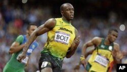 Pelari Jamaika, Usain Bolt (tengah) mengukuhkan dominasi sebagai manusia tercepat di dunia, setelah kembali memenangkan medali emas nomor 200 meter putera, Kamis (9/8). 