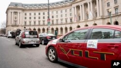 Protesters with Environment America park fuel-efficient vehicles outside the Environmental Protection Agency as EPA Administrator Scott Pruitt holds a news conference on his decision to scrap Obama administration fuel standards, in Washington, April 3, 2018.