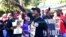 In this May 5, 2020, photo, Keith Smith speaks to a crowd as they march through a neighborhood in Brunswick, Ga. 