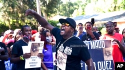 In this May 5, 2020, photo, Keith Smith speaks to a crowd as they march through a neighborhood in Brunswick, Ga. They were demanding answers regarding the death of Ahmaud Arbery. 