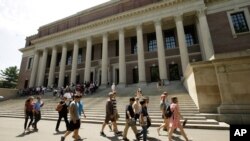 Estudiantes pasan frente a una entrada a la biblioteca Widener en el campus de la Universidad de Harvard, en Cambridge, Massachusetts, el 16 de julio 2019.