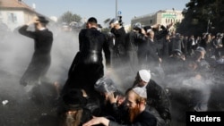 Israeli ultra-Orthodox Jewish men are sprayed with water canons during clashes with police at a protest against the detention of a member of their community who refuses to serve in the Israeli army, in Jerusalem, Israel, Sept. 17, 2017. 