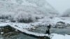 Seorang anak laki-laki Afghanistan berjalan melintasi jembatan penyeberangan saat salju turun di distrik Dara, provinsi Panjshir, Afghanistan. (AFP)&nbsp;