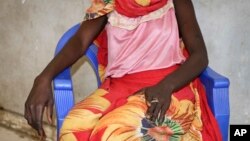 FILE - A young woman says that on a day in early November she and a friend were bound, dragged into the bush and raped by four men with guns, as she sits in a hospital in Nhialdu, South Sudan, Dec. 7, 2018.
